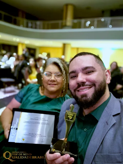 Sol Lima e um acompanhante registram o momento com a placa e o troféu.