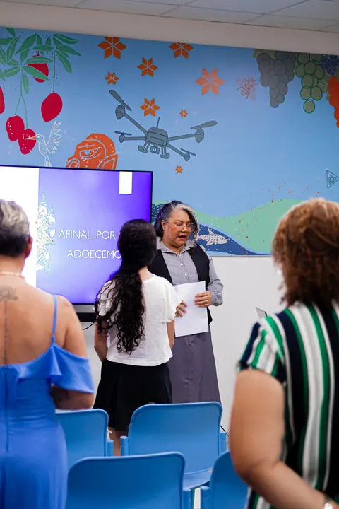 Mulheres reunidas em uma sala durante uma apresentação do TPMe.