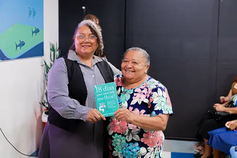 Duas mulheres compartilham um momento de encontro e acolhimento.