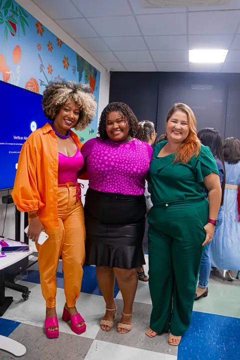 Três mulheres sorriem juntas em um registro da segunda edição do TPMe.
